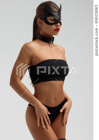 Seductive brunette in BDSM costume 69029065
