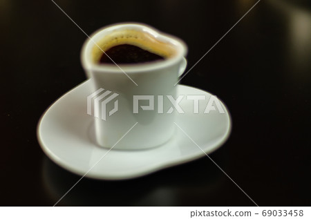 black coffee in a ceramic cup on the bar, energy 69033458