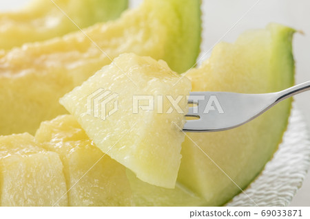 Eating ripe melon with a fork Eating ripe melon with a fork 69033871