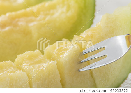 Eating ripe melon with a fork Eating ripe melon with a fork 69033872