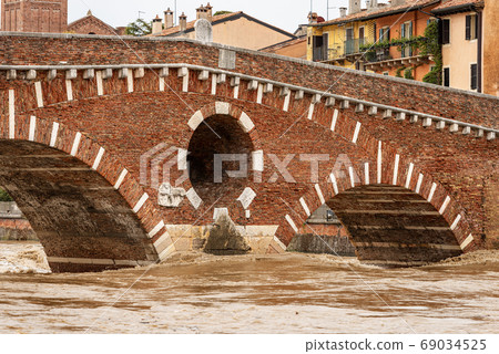 Ponte Pietra - Stone bridge and Adige river in flood - Verona Italy Ponte Pietra - Stone bridge and Adige river in flood - Verona Italy 69034525