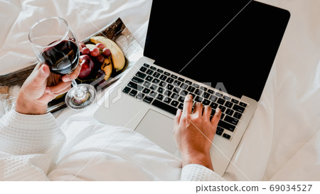 Picture of tourists used laptop and eating fruits on the bed, health food concept 69034527