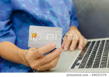 Seniors woman holding credit cards 69035379