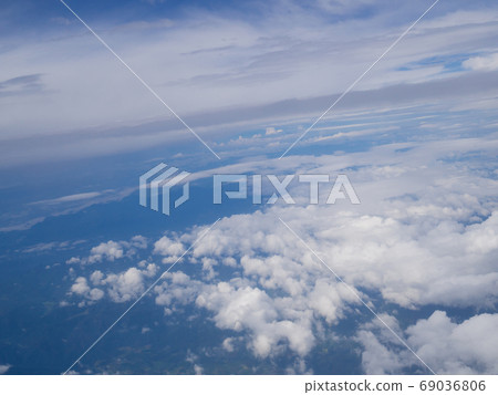 Clouds from airplane window with blue sky and high angle ground Clouds from airplane window with blue sky and high angle ground 69036806