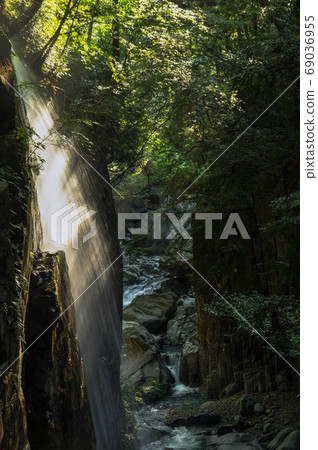 Valley waterfall illuminated by the morning sun 69036955