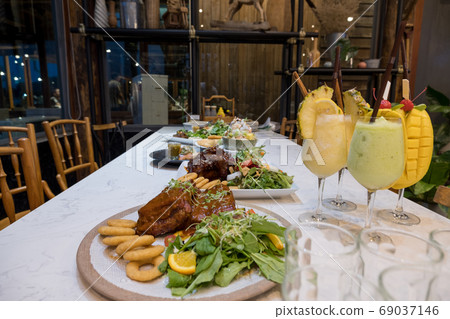 Steaks, salads and fruit juices are prepared on the food table Steaks, salads and fruit juices are prepared on the food table 69037146