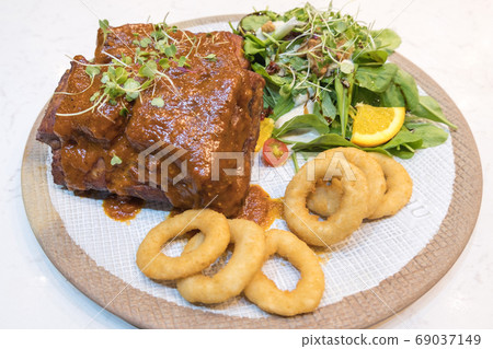 Pork Rib Steak Organic salad vegetables In a white tile dish with fried onions 69037149