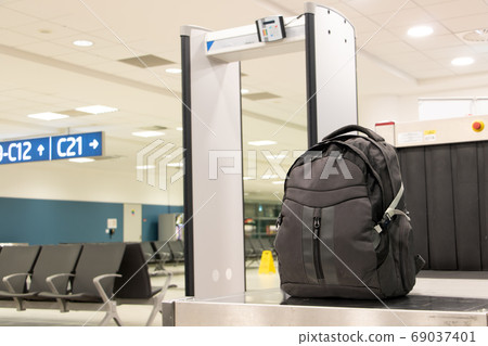 Backpack standing in front of luggage scanner at 69037401