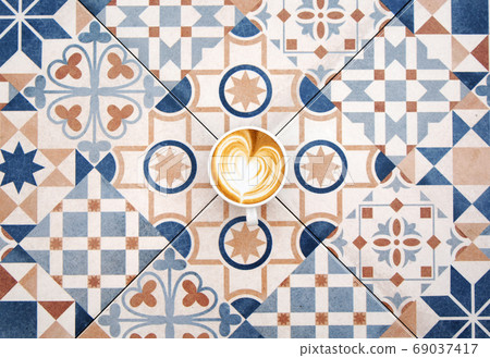 Cup of latte coffee on colorful tile background 69037417