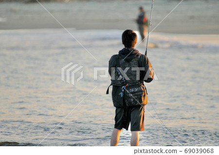 Rear view of angler bathing in the sunset Rear view of angler bathing in the sunset 69039068