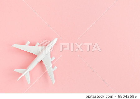 White model plane, airplane on pink background. Top view, flat lay. Banner. White model plane, airplane on pink background. Top view, flat lay. Banner. 69042689