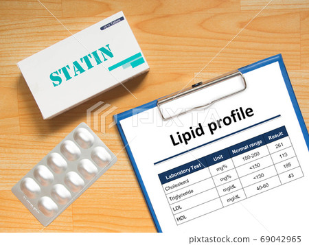 Laboratory results chart of lipid profile showing high blood cholesterol levels and generic pack of statins tablets for treatment dyslipidemia patient on wood table. Health care and medical concept. 69042965