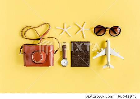 Traveler accessories concept on yellow background. Retro camera, model plane, airplane, sunglasses. Summer background. Traveler accessories concept on yellow background. Retro camera, model plane, airplane, sunglasses. Summer background. 69042973
