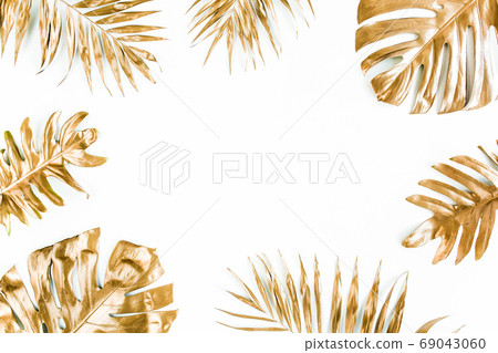 Gold tropical palm leaves Monstera on white background. Flat lay, top view minimal concept. Gold tropical palm leaves Monstera on white background. Flat lay, top view minimal concept. 69043060