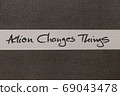 White and Grey coloured paper background with Action Changes Things motivational handwritten message 69043478