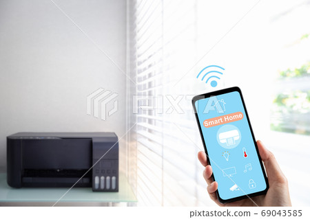 hand holding mobile phone with smart home screen 69043585
