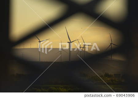 Blurred wind turbines in the distance, Aragon, Spain Blurred wind turbines in the distance, Aragon, Spain 69043906