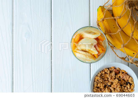 Tasty breakfast with granola, yoghurt and fruits in a glass bowl Tasty breakfast with granola, yoghurt and fruits in a glass bowl 69044603