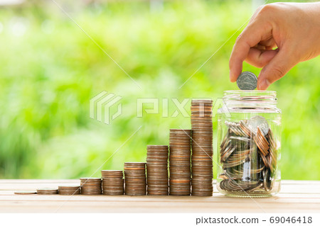 White hand man holding coin to putting in Jar or 69046418