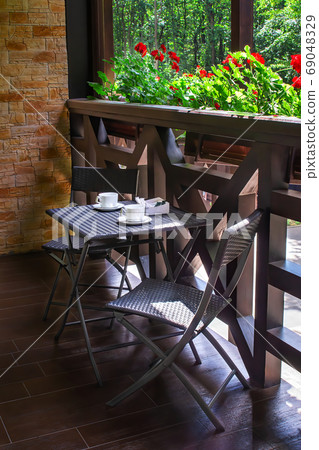 Nice terrace or balcony with small table, chairs and cups. Rest zone. Tea party for two. 69048329