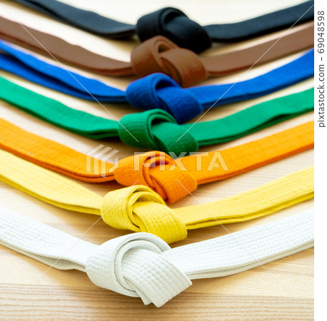 Martial arts colored belts on a wood background. Martial arts colored belts on a wood background. 69048598