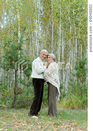 Portrait of senior couple walking in autumn forest 69048802
