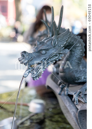 Metal dragon spewing water in the well in the Senso-ji temple, Tokyo, Japan. Metal dragon spewing water in the well in the Senso-ji temple, Tokyo, Japan. 69049158