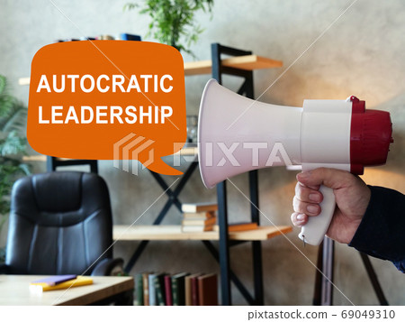 Autocratic leadership concept. Loudspeaker in hand and sign. 69049310