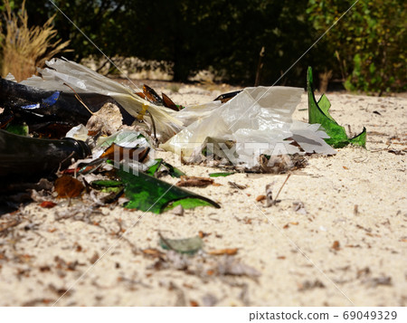 Rubbish, glass bottles on the ground in the forest. 69049329