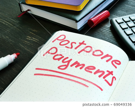 Postpone payments red memo on the page and calculator. Deferment or Forbearance concept. Postpone payments red memo on the page and calculator. Deferment or Forbearance concept. 69049336