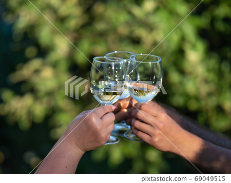 Wine glasses in hands of couple Wine glasses in hands of couple 69049515