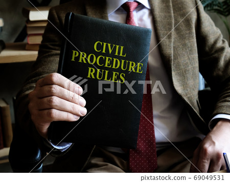 Civil Procedure Rules. Businessman holds a book in his hands. 69049531
