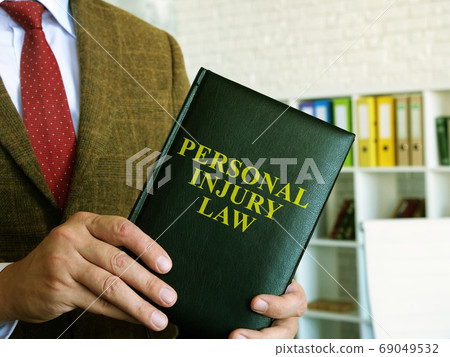 Personal injury law. A lawyer in a suit holds a book. 69049532
