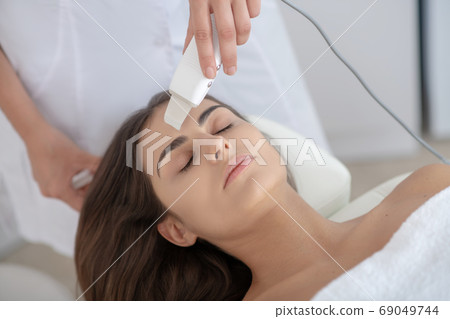 Dark-haired woman having laser skin treatment in the clinic 69049744