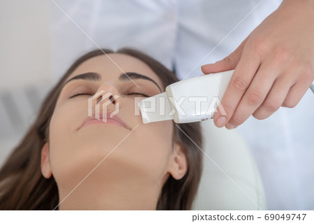 Dark-haired woman having laser skin treatment in the salon 69049747