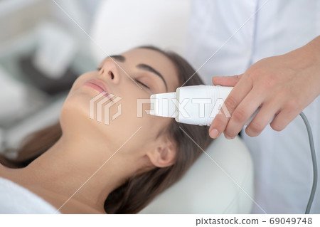 Dark-haired woman having beauty treatment in the salon and feeling relaxed 69049748