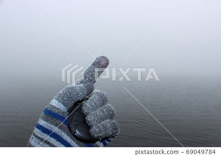 A man's hand in a woolen glove. In the palm of his A man's hand in a woolen glove. In the palm of his 69049784