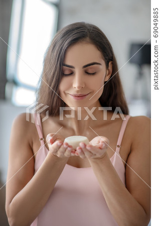 Beautiful woman smelling a fragrance of soap Beautiful woman smelling a fragrance of soap 69049885