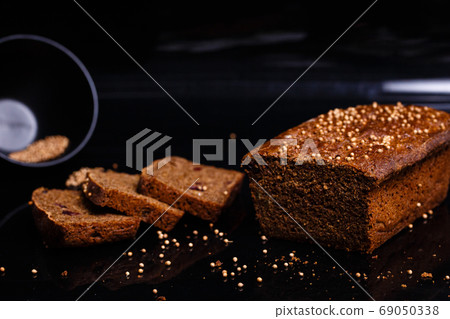 Homemade black bread on a black background. Photo in section. Homemade black bread on a black background. Photo in section. 69050338