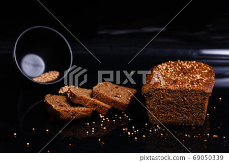Homemade black bread on a black background. Photo in section. Homemade black bread on a black background. Photo in section. 69050339