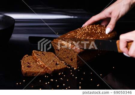 Homemade black bread on a black background. Photo in section. Homemade black bread on a black background. Photo in section. 69050346