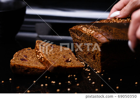 Homemade black bread on a black background. Photo in section. 69050350