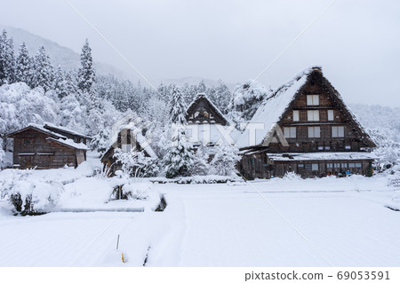 ancient houses and white snow is heavy and covered throughout  Shirakawa-go village in Gifu, Japan. 69053591