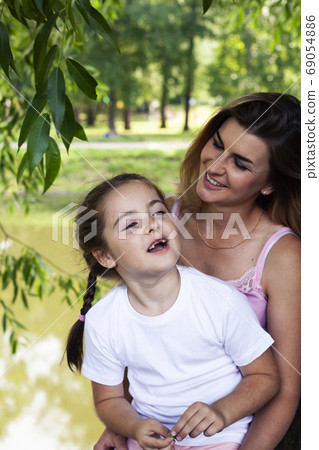 young pretty mother walking with little cute daughter outside in green park, lifestyle poeple concept young pretty mother walking with little cute daughter outside in green park, lifestyle poeple concept 69054886