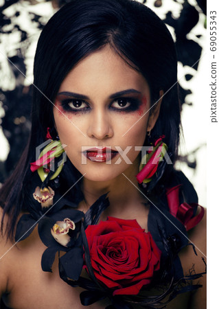 pretty brunette woman with rose jewelry, black and red, bright make up kike a vampire closeup red lips pretty brunette woman with rose jewelry, black and red, bright make up kike a vampire closeup red lips 69055343