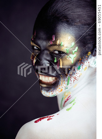 woman with creative makeup closeup like drops of colors, facepaint close up halloween 69055451