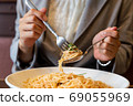 Working woman eating pasta spaghetti at lunch 69055969