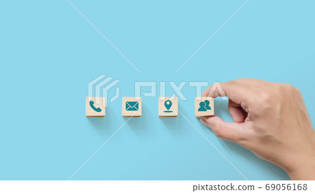 Hand putting wooden with symbol telephone, email, address Hand putting wooden with symbol telephone, email, address 69056168