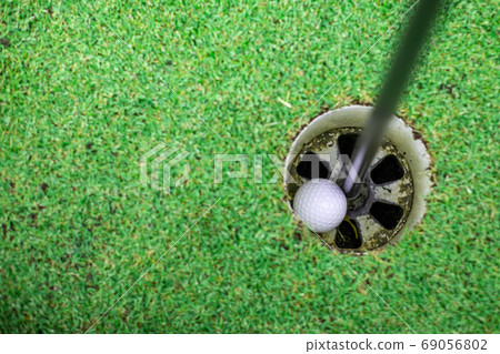 the golf ball in the golf hole. the golf ball in the golf hole. 69056802