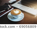 A latte coffee and laptop on the table.. 69056809
